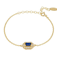 Gold gemstone bracelet with blue sapphire centerpiece and linked chain