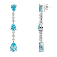 Silver drop earrings with blue topaz stones, shown in side view