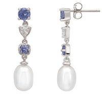 Silver drop earrings with blue gemstone settings and pear-shaped pearl, shown from side
