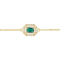 Close-up of gold chain bracelet with emerald green gemstone centerpiece