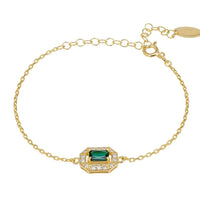 Gold chain gemstone bracelet with emerald green center stone in ornate setting