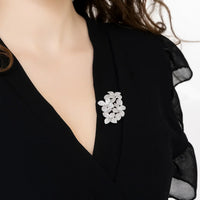 Silver flower brooch on black V-neck top
