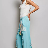 Cream sleeveless tank with studded trim, button placket, and ruffle detail