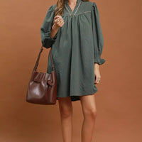 Stone-blue textured mini dress with puff sleeves and front yoke, standing view