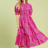 Pink patterned smocked midi dress with ruffle collar, puff sleeves, and tiered skirt