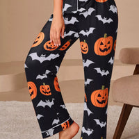 Halloween pajama set: dark navy pants with orange pumpkin and bat prints, cuffed legs