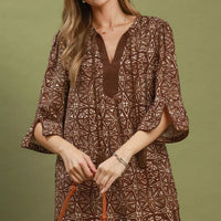 Brown geometric print tunic dress with V-neck tassel detail, flared sleeves
