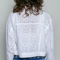 Back view of off white eyelet textured cropped button jacket with long sleeves