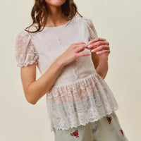 Model wearing light-wash denim shorts with rose embroidery