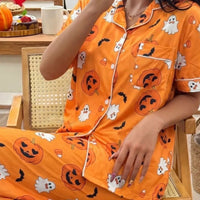 Halloween pajama set: orange button-up top and pants with pumpkin, ghost, and bat prints