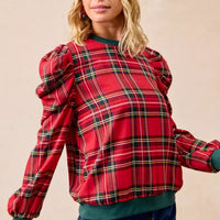 Red plaid puff-sleeve top with exaggerated shoulders and green ribbed cuffs at wrists