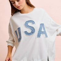 Ivory french terry top featuring large blue "USA" appliqued letters and cuffed sleeves