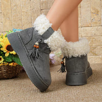 Pair of gray ankle boots with round toe, faux fur lining, tassel and bead accents