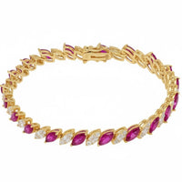 Gold tennis bracelet with oval ruby-red stones in a hinged link setting