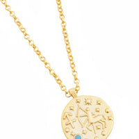Gold zodiac talisman necklace with round pendant and blue accent stone