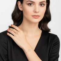 Gold open clover charm bracelet worn on model's wrist