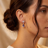 Silver drop earrings on model with crystal starburst and deep blue teardrop stones