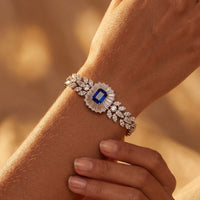 Silver gemstone bracelet on wrist with blue sapphire centerpiece