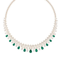 Gold choker-style necklace with emerald green teardrop stones in a collar curve