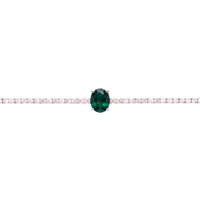 Silver tennis bracelet close-up with emerald green oval gemstone set in white stones