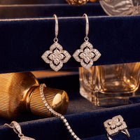 Silver CZ clover flower drop earrings, shown side by side