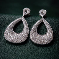 Silver teardrop earrings with pavΓ©-set stones and open teardrop design