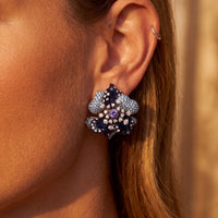 Blue flower stud earrings with purple center stones in silver-tone setting.