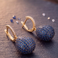 Gold hoop drop earrings with sapphire blue pavé gemstone domes