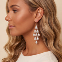 Silver-tone pearl teardrop chandelier earrings dangling from ear, side view