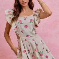 Ivory floral romper with ruffled cap sleeves, pleated waist and pink rose print