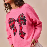 Pink sweater with plaid ribbon bow detail and ribbed cuffs