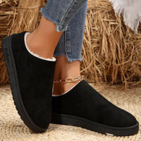 Black plush lined ankle boots with round toe, side profile and stacked rubber sole.