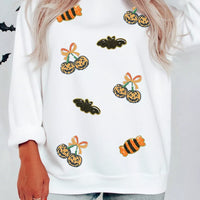 White sequin pullover sweatshirt with scattered jack-o'-lantern, bat, and candy motifs
