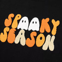 Close-up of embroidered “Spooky Season” graphic on black crewneck sweatshirt