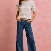 Mid-rise stretch denim jeans, full-body view with wide-leg flare and button fly
