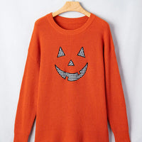 Orange knit sweater with jack-o'-lantern graphic, round crew neck, long sleeves
