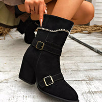 Black suede ankle boots with block heel, point toe, buckled straps and decorative trim.