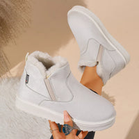 White plush-lined ankle boots with stitched seams and soft faux-fur trim