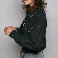 Black cropped eyelet cotton jacket, button-front, with curved stitched flap pockets and sleeves.