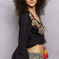 Black cropped blouse with floral embroidery and tassel drop at V-neck