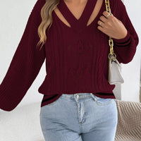 Burgundy cutout cable knit sweater with V-neck and decorative knit motifs