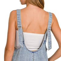 Back view of light wash denim overall dress with open-back neckline