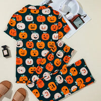 Flat lay of pumpkin-printed short-sleeve top and matching lounge pants, dark green