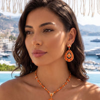 Gold fire opal drop earrings with orange teardrop centerpiece and round crystal details