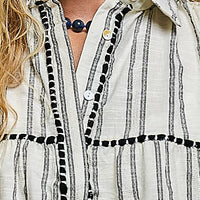 Grey multi-striped sleeveless cotton top close-up with button collar and black trim