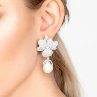 Flower drop clip-on earrings with silver glitter flower and white pearl drop, close-up