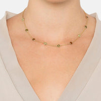 Gold chain necklace with oval green stones and brown discs on collar