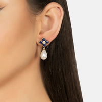 Gold-tone navy clover earrings with crystal detail and white pearl drops on ear