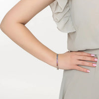 Heart tennis bracelet on wrist with multicolored stone charms and silver chain