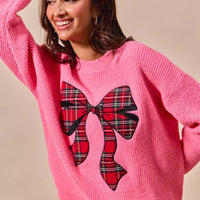 Pink holiday sweater with plaid ribbon bow graphic